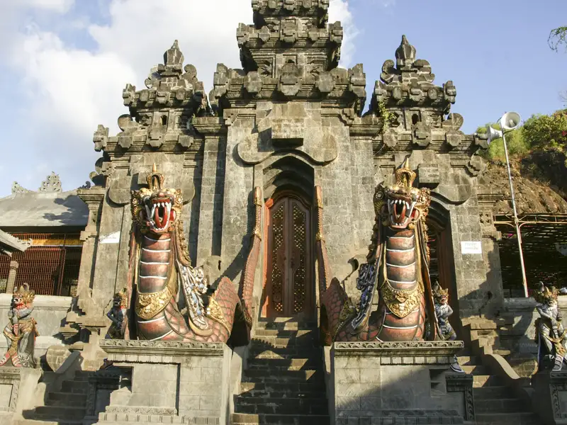 Eingangstor eines balinesischen Tempels, bewacht von zwei Schlangenstatuen.