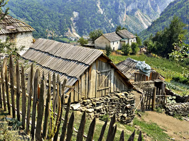Holzhäuser und -zäune in einem Bergdorf.