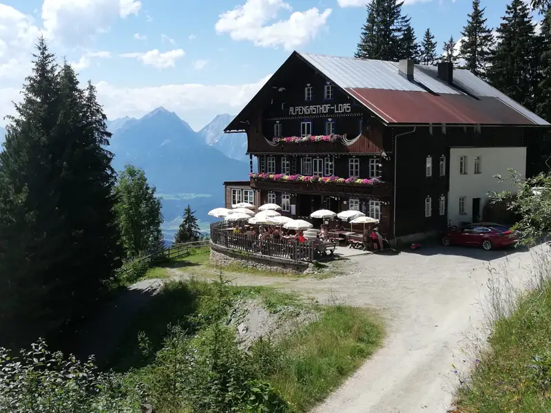 Berglandschaft mit Wasserfall und grüner Vegetation.