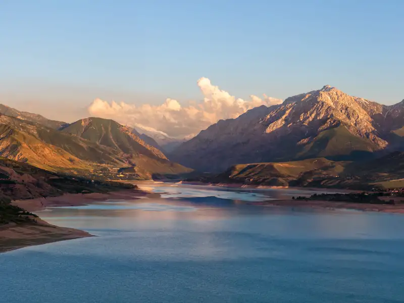 Panoramablick auf einen Bergsee und die umliegende Berglandschaft.