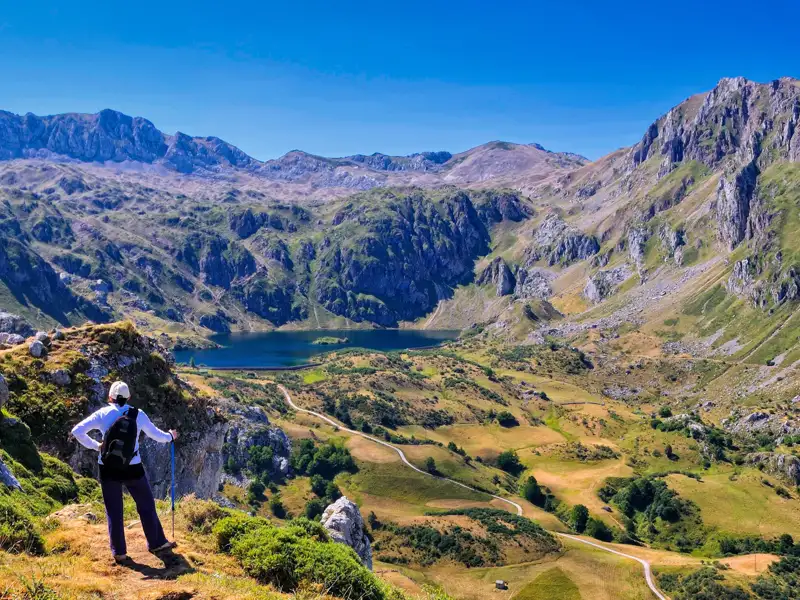 Wanderer betrachtet Bergsee und Landschaft.