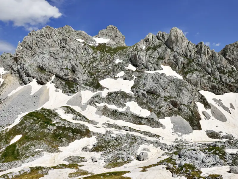 Schroffe Felslandschaft mit Schneefeldern in den Bergen.