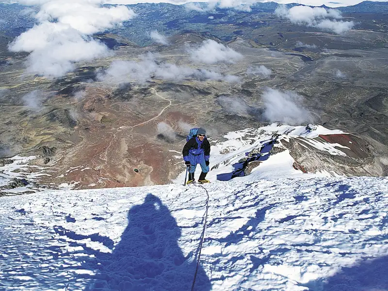 Bergsteiger beim Aufstieg eines verschneiten Berges.