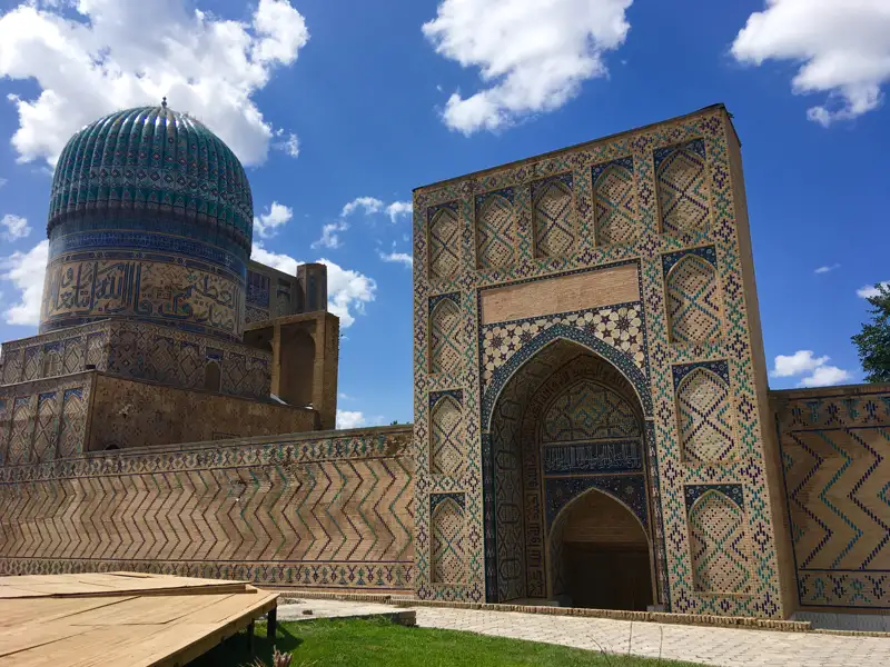 Grüne Kuppel und verziertes Tor eines historischen Gebäudes.