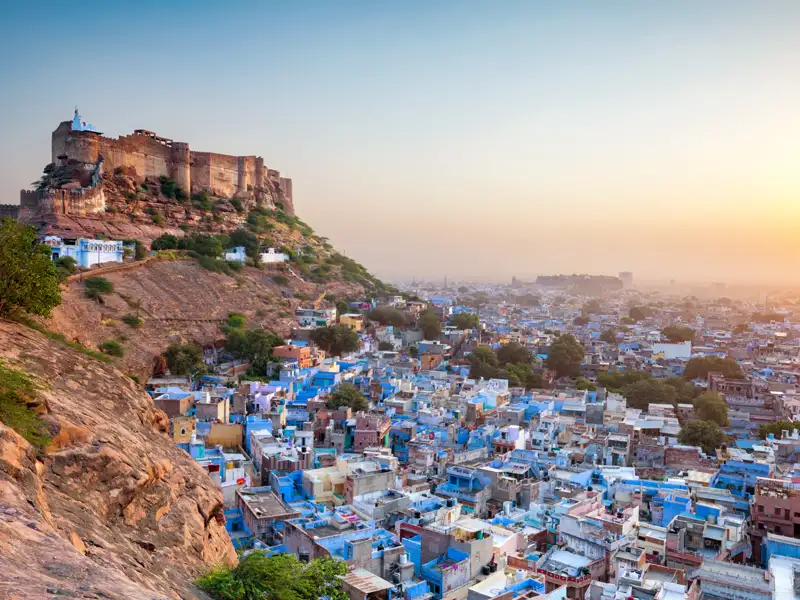 Panorama von Jodhpur mit den blauen Häusern und dem Mehrangarh Fort bei Sonnenaufgang.