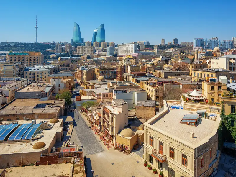 Panoramablick auf die Altstadt von Baku mit ihren historischen Gebäuden und den modernen Flame Towers im Hintergrund.