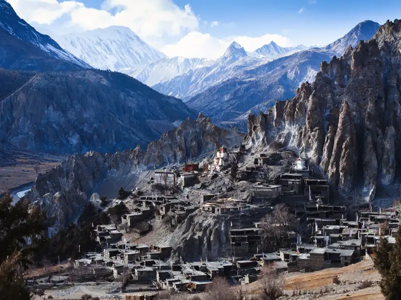 Traditionelles Bergdorf im Himalaya, umgeben von beeindruckender Berglandschaft.