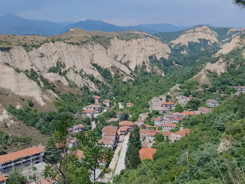Panoramablick auf ein Dorf in einer bergigen Region.