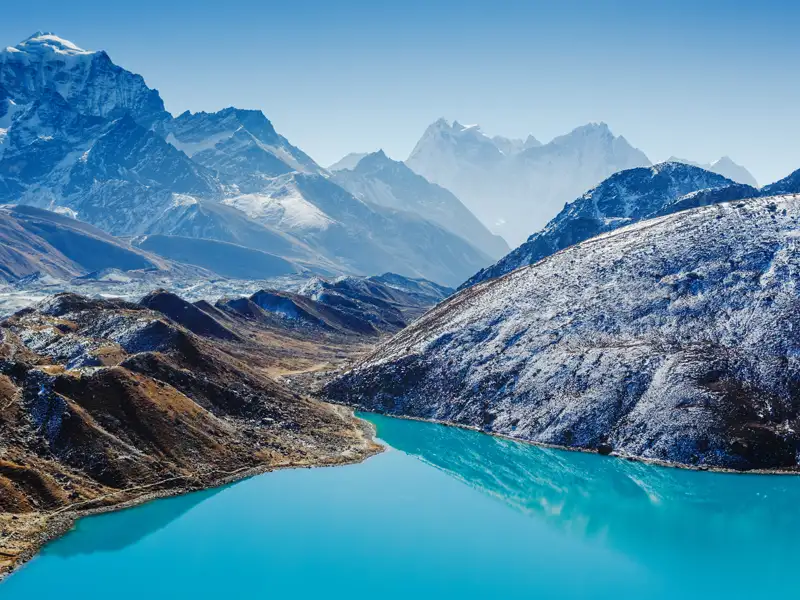 Türkisfarbener See und schneebedeckte Berge.