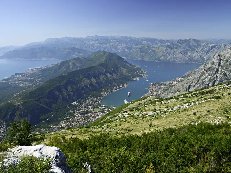 Aussicht auf die Bucht von Kotor von einem erhöhten Standpunkt aus. Die Landschaft zeigt die Berge, das Wasser und die Küstenstädte.