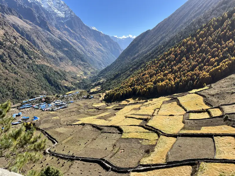 Berglandschaft mit Dorf und terrassierten Feldern.