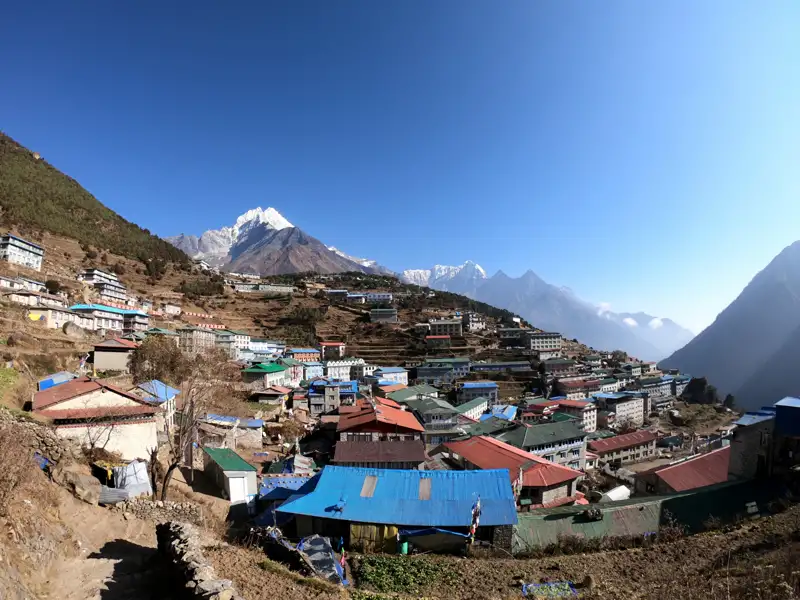 Panoramablick auf ein Bergdorf im Himalaya mit Blick auf die schneebedeckten Gipfel.