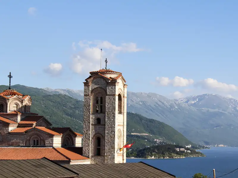 Kirche am See mit Bergen im Hintergrund