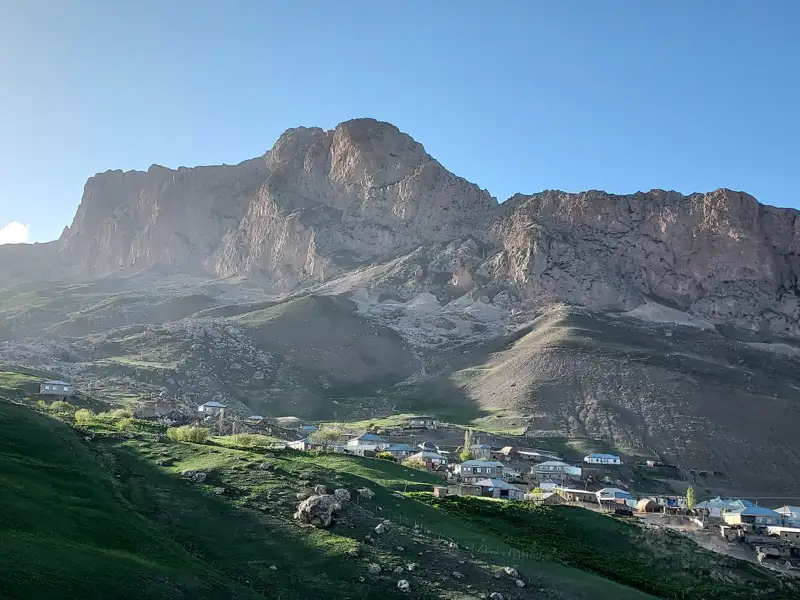 Blick auf ein Bergdorf mit einem imposanten Berg im Hintergrund.