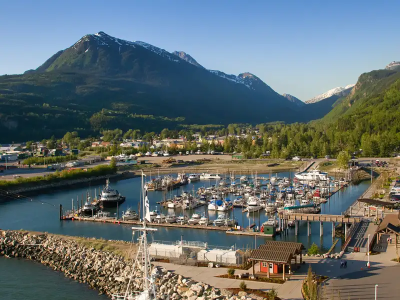 Hafen mit Booten und Bergkulisse.