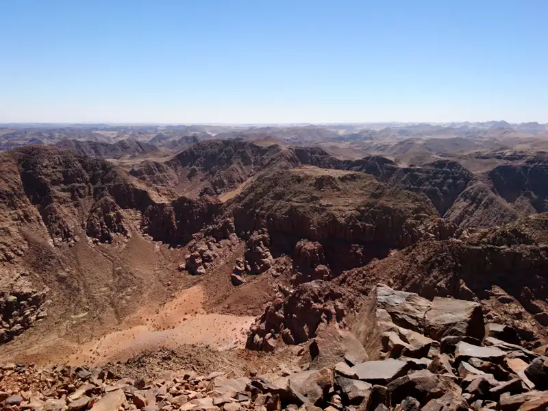 Felsige Wüstenlandschaft unter blauem Himmel.
