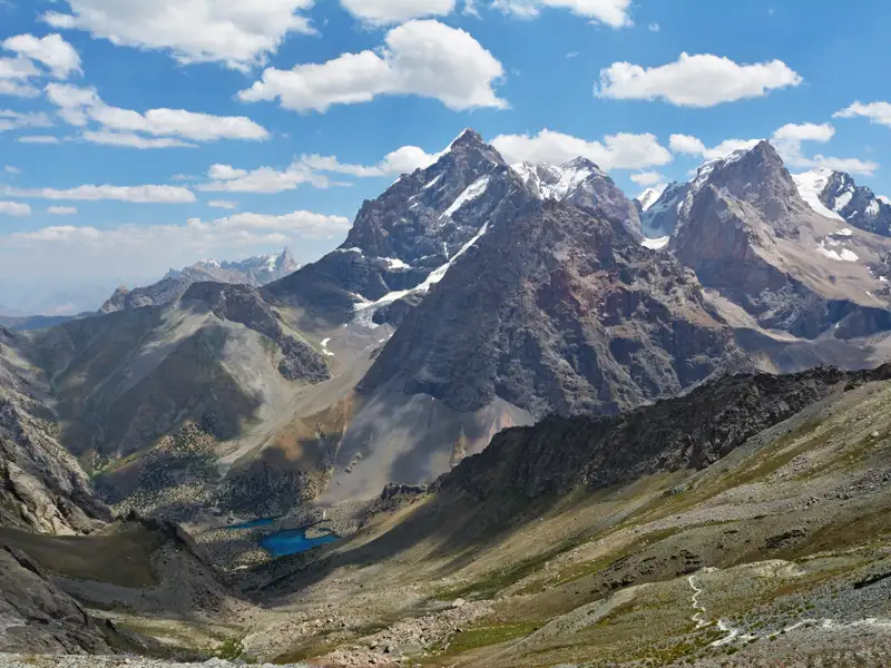 Schneebedeckte Berggipfel und ein Tal im Vordergrund.