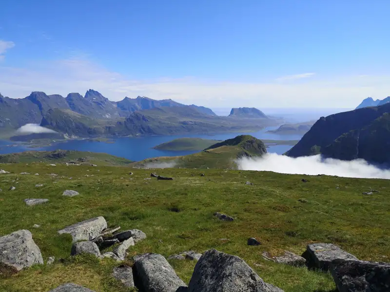 Aussicht von einem Berg auf eine Küstenlandschaft mit Wasser und Inseln.