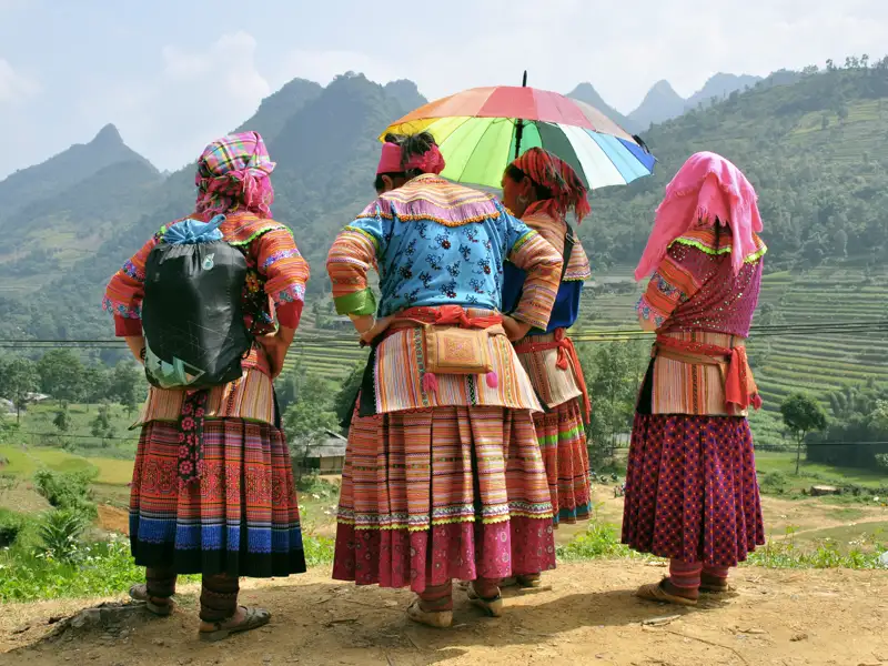 Vier Frauen in traditioneller Kleidung mit Blick auf die Berglandschaft.