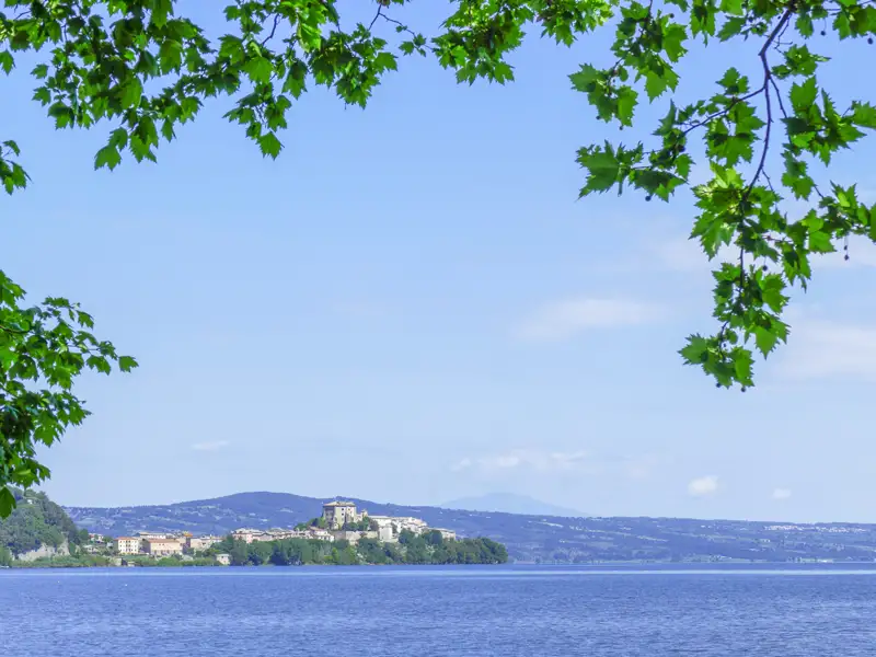Blick auf den See und die Stadt am Ufer, umgeben von einer hügeligen Landschaft.
