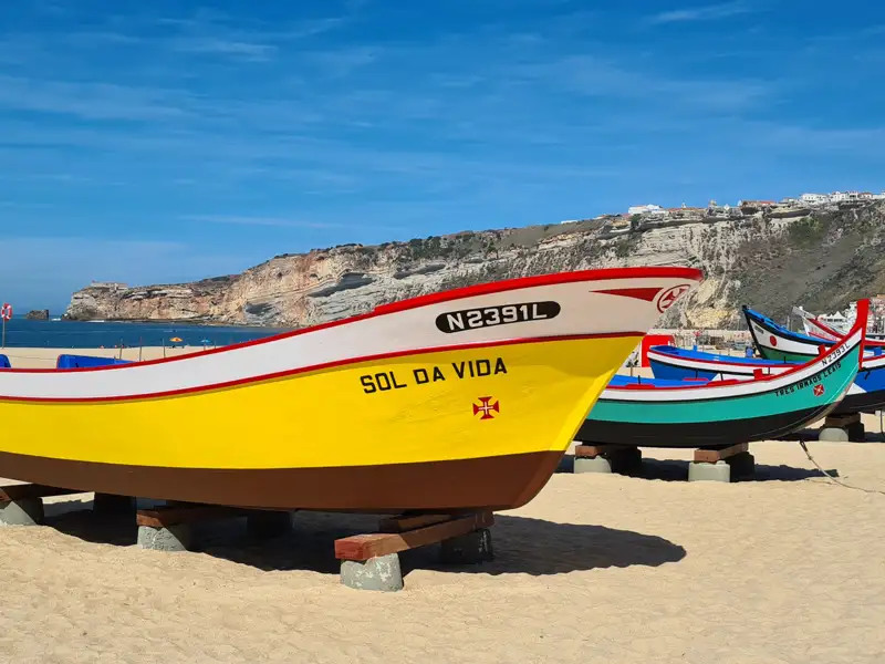 Fischerboote am Strand, möglicherweise Hinweis auf lokale Fischerei oder Bootstouren.
