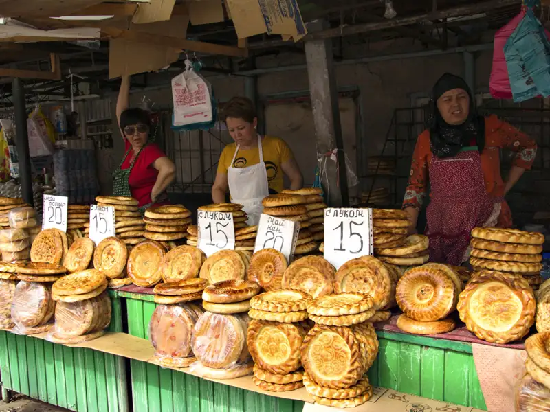 Marktstand mit verschiedenen Fladenbroten und drei Verkäuferinnen.