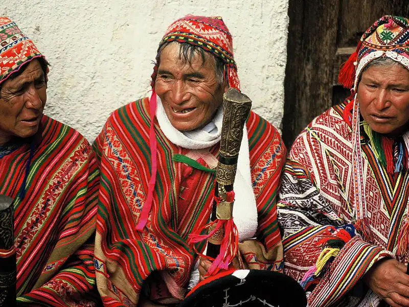 Drei Personen in traditioneller Andenkleidung.