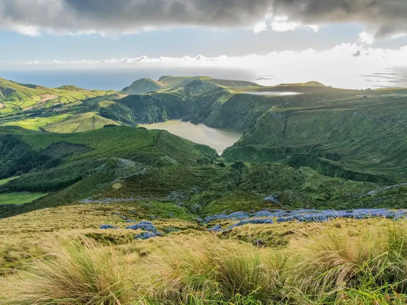 Aussicht auf einen vulkanischen Kratersee auf den Azoren, umgeben von üppiger Vegetation.