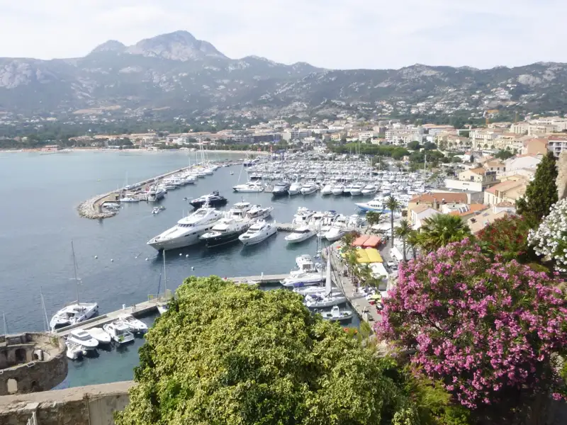 Panoramablick auf den Hafen mit zahlreichen Booten und Yachten, die Stadt und die umliegenden Berge.