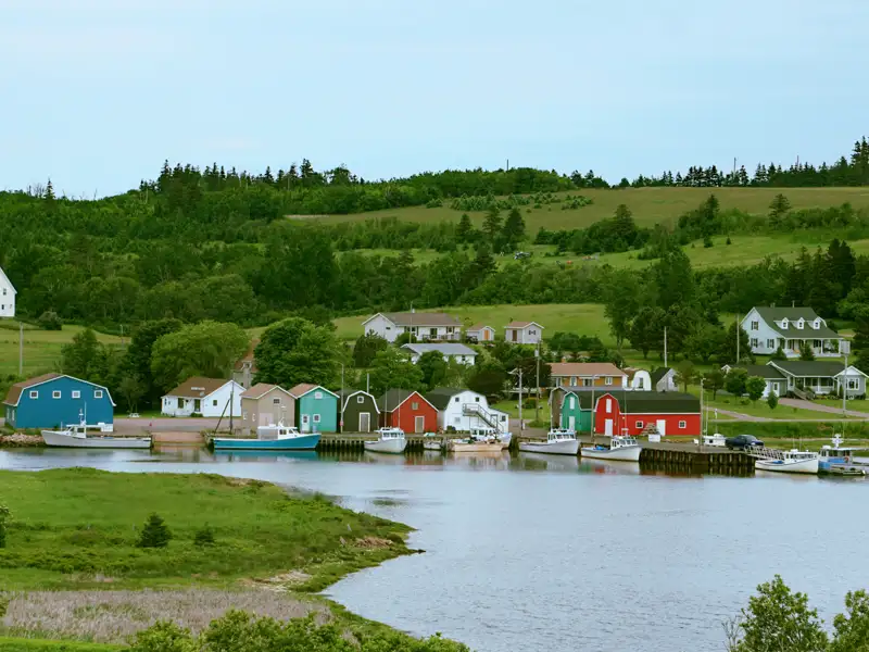 Idyllisches Fischerdorf mit bunten Bootshäusern und Booten.