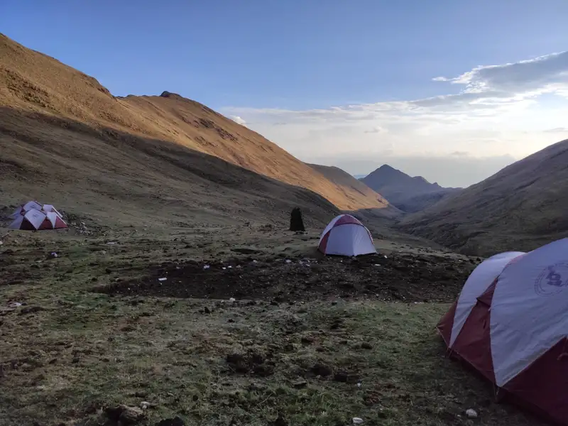 Campingplatz in den Bergen mit mehreren Zelten.