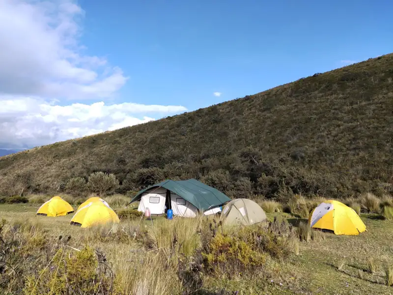 Campingplatz mit verschiedenen Zelten in den Bergen.