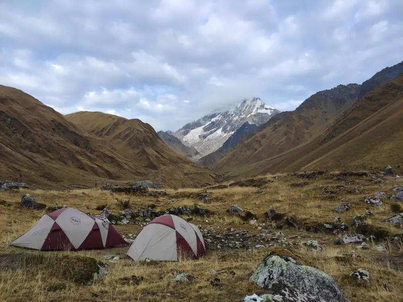Campingplatz im Hochgebirge mit Blick auf einen schneebedeckten Berg.