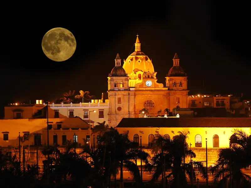Beleuchtete Kirche bei Nacht mit Mond.