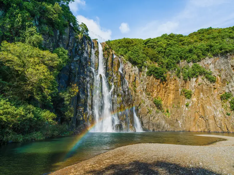 Spektakulärer Wasserfall mit Regenbogen im Sprühnebel.