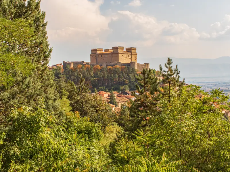 Historisches Schloss auf einem Hügel mit Blick auf die umliegende Landschaft.