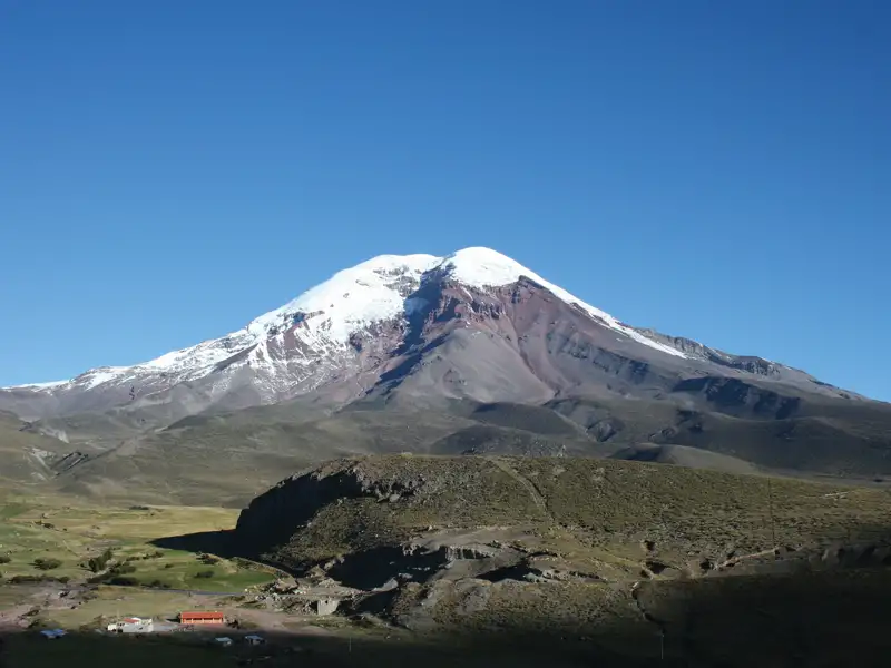 Schneebedeckter Berggipfel unter blauem Himmel.