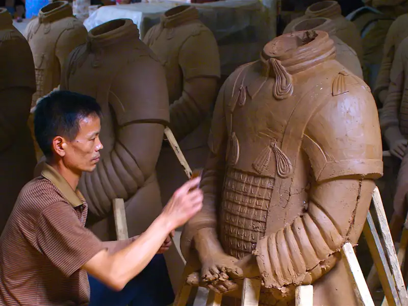 Herstellung einer Terrakotta-Figur: Ein Künstler arbeitet an den Details der Rüstung.
