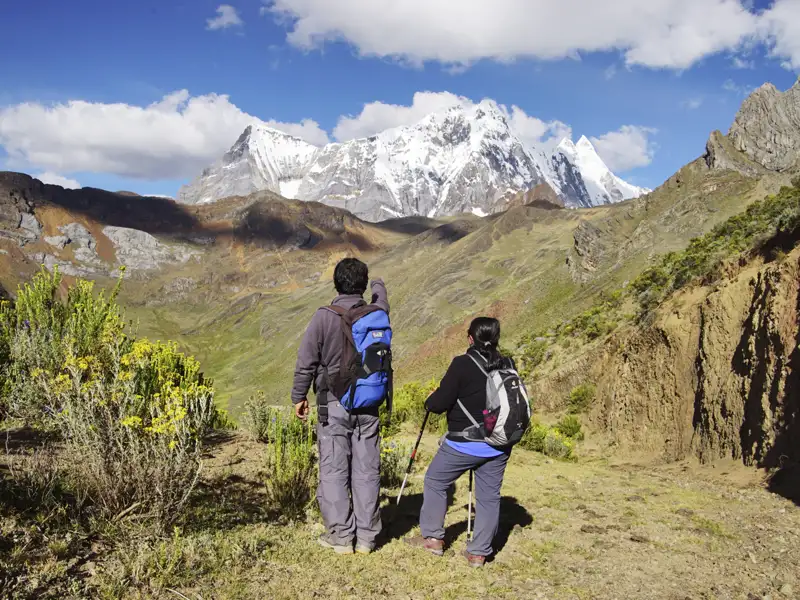 Zwei Wanderer genießen den Ausblick auf die Anden.