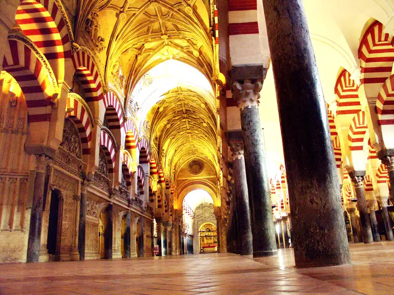 Die ikonischen rot-weißen Bögen und Säulen im Inneren der Mezquita-Kathedrale in Córdoba, Spanien.