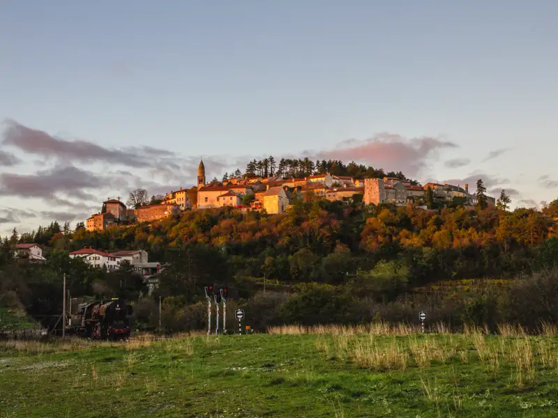 Historische Stadt auf einem Hügel bei Sonnenuntergang