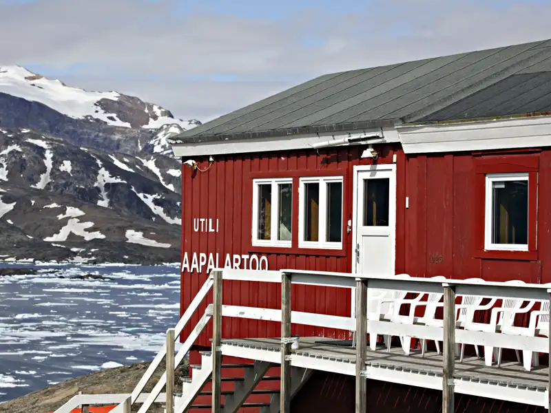 Das Gebäude "Utili Aapalarttoo" an der Küste mit Blick auf die eisbedeckte Landschaft.