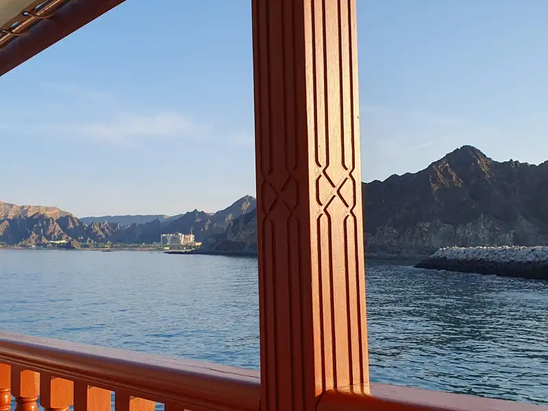 Aussicht von einem traditionellen Holzboot auf die bergige Küste.