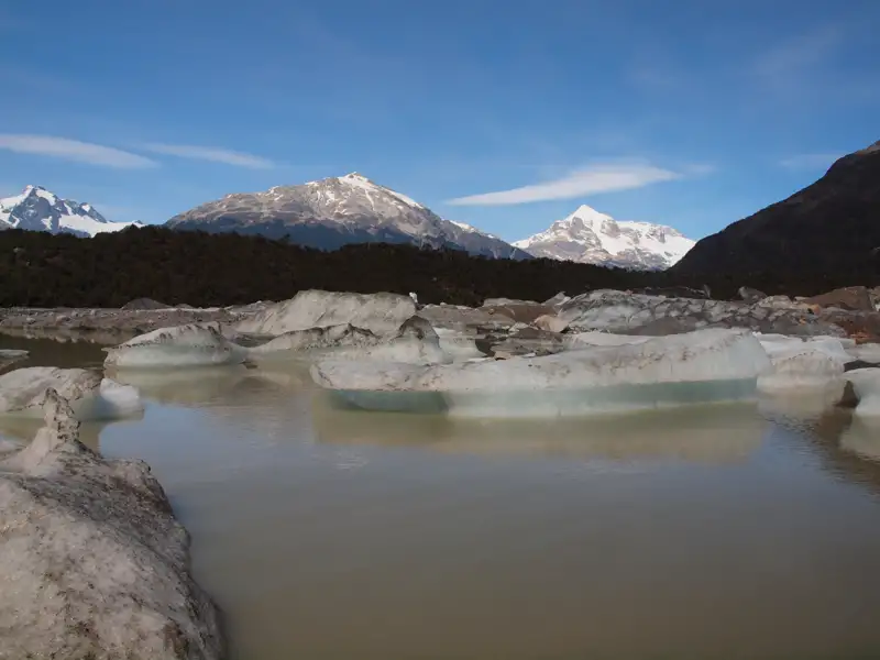 Eisberge im See vor schneebedeckten Bergen.