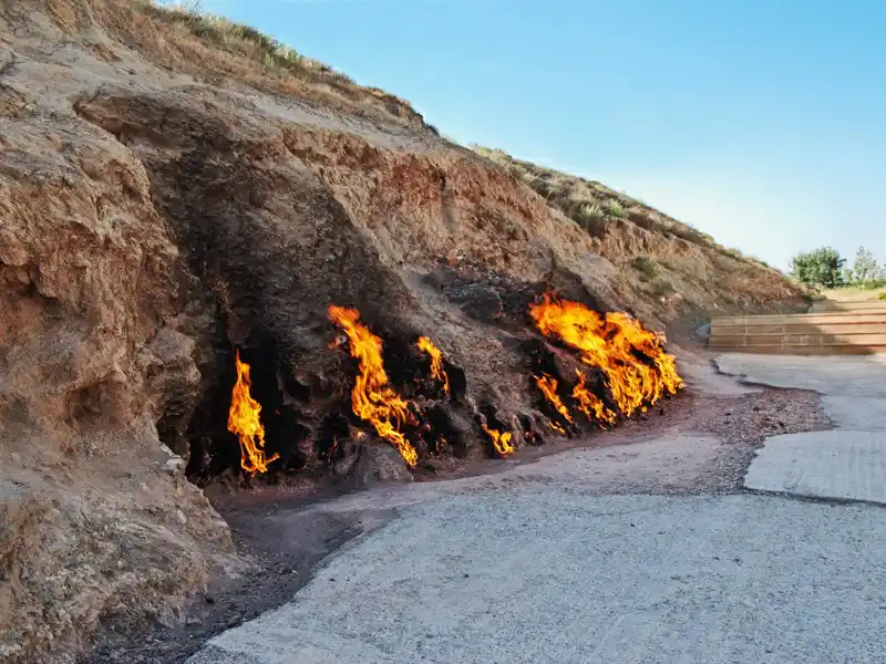 Flammen aus Steinen an einem Berghang.