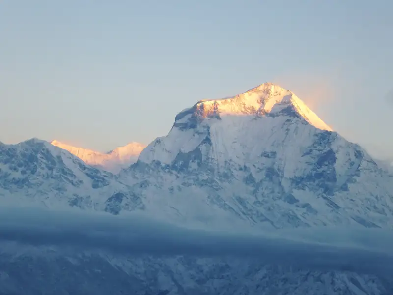 Schneebedeckter Berggipfel in der Morgensonne.