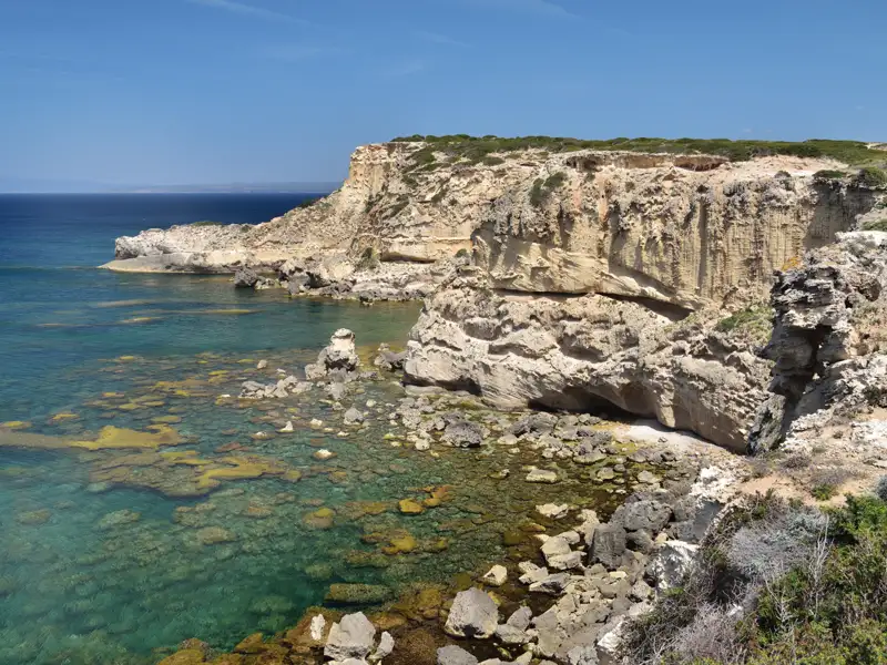 Felsige Küstenlandschaft mit klarem Wasser.