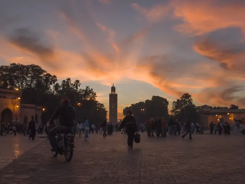Sonnenuntergang über einem Platz mit Minarett.
