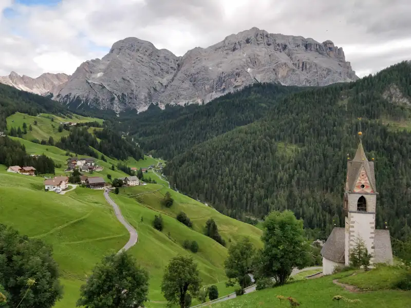 Alpendorf mit Kirche und Berglandschaft