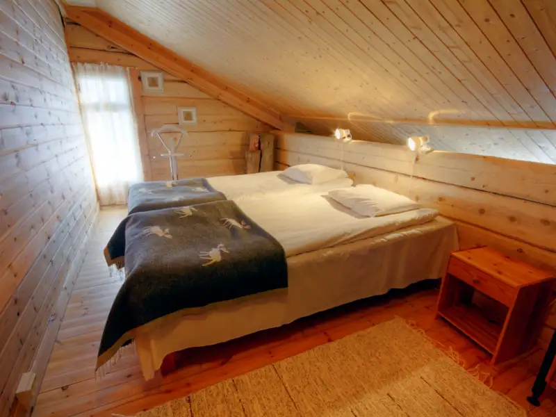 Doppelbett im Schlafzimmer im Dachgeschoss der Holzhütte.